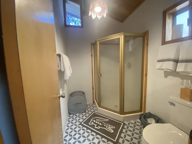 a bathroom with a granite countertop shower and a toilet