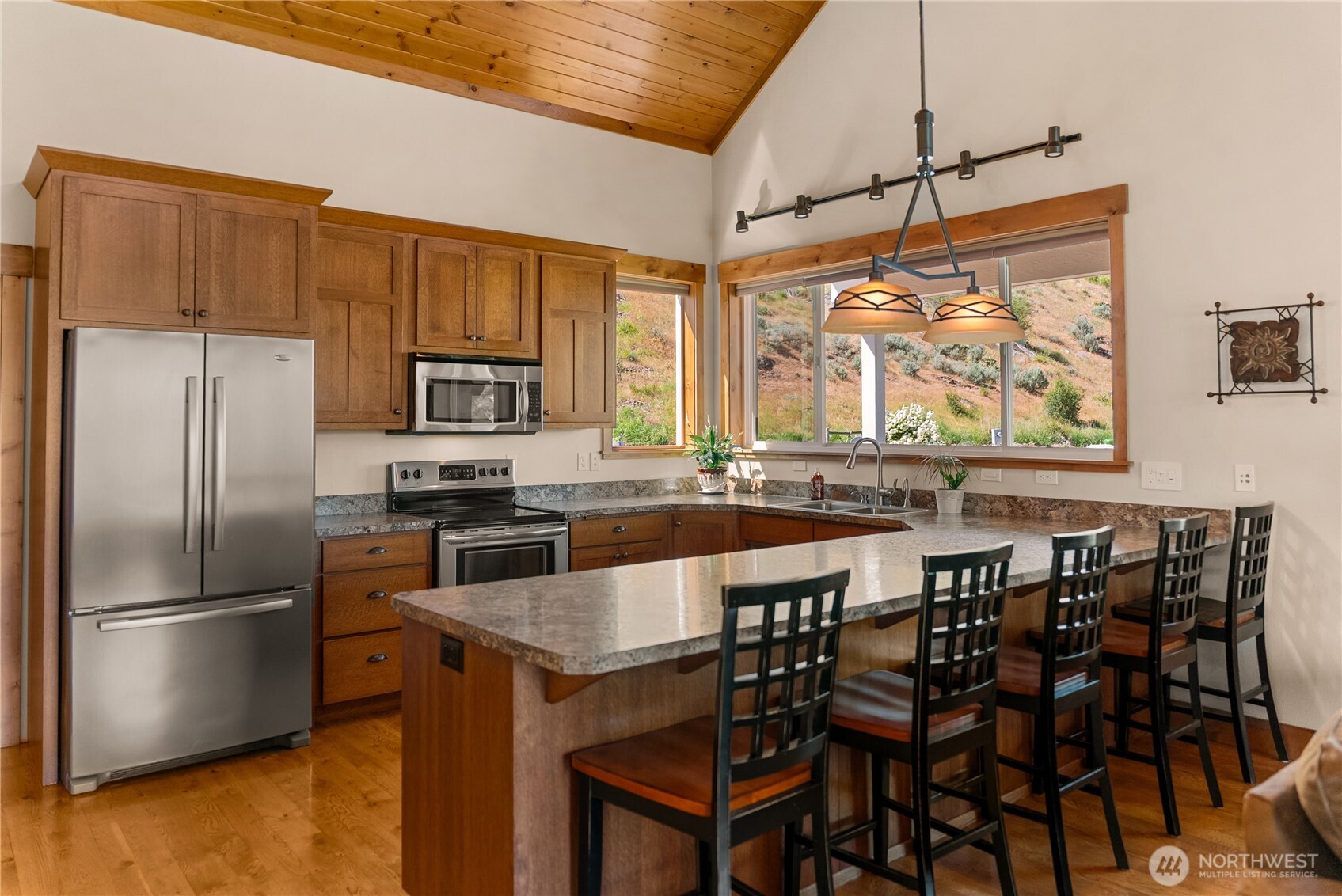 23 George Road Omak, WA 98841 - Photo 15 of 40 a kitchen with granite countertop a table chairs stove and refrigerator