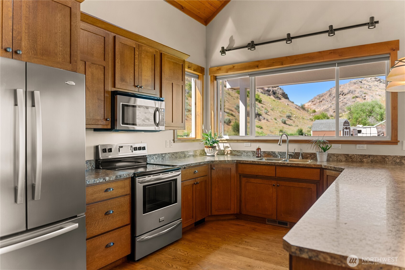 23 George Road Omak, WA 98841 - Photo 16 of 40 a kitchen with stainless steel appliances granite countertop a stove a sink and a refrigerator