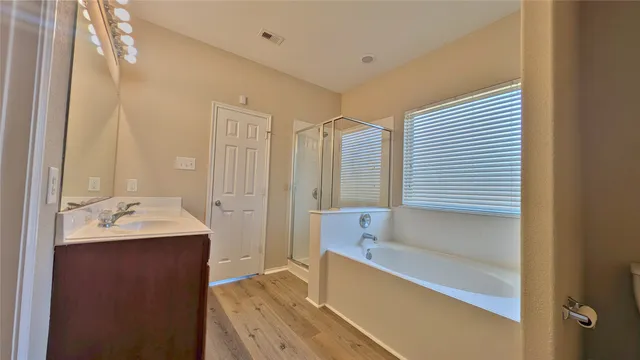 a bathroom with a tub sink and mirror