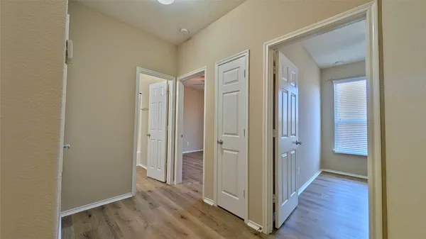 a view of a hallway with wooden floor
