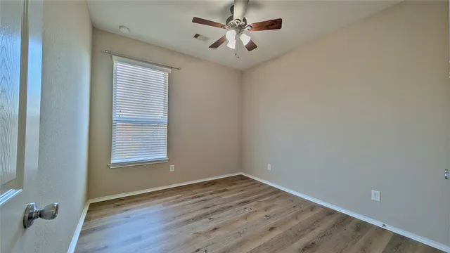 wooden floor in an empty room with a window