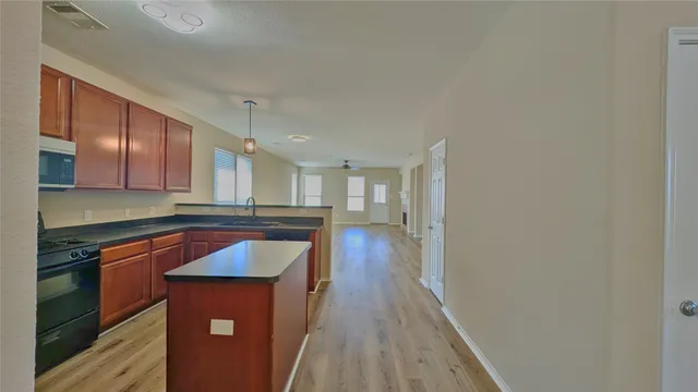 a kitchen with stainless steel appliances granite countertop a stove a sink and a refrigerator