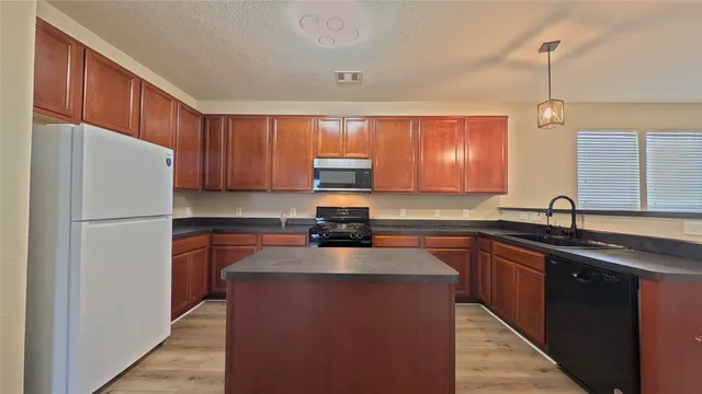 a kitchen with a sink a refrigerator and cabinets