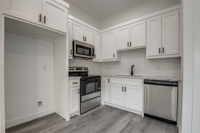 a kitchen with cabinets stainless steel appliances and a sink