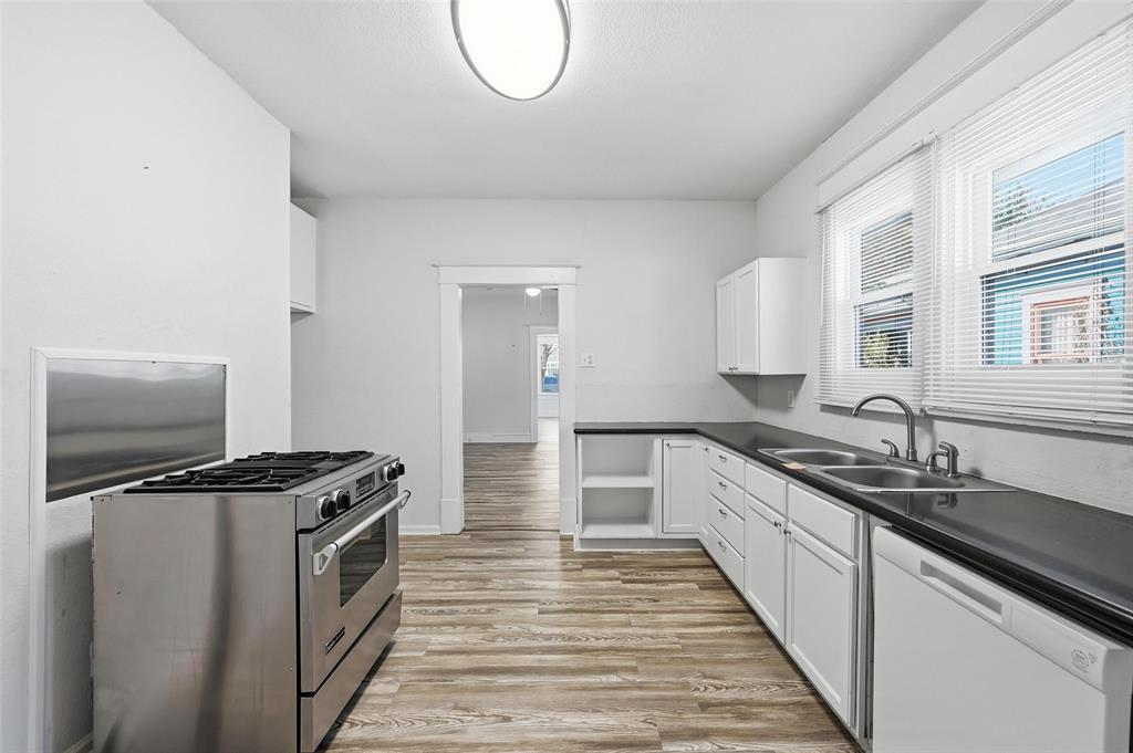 526 South Clinton Avenue Dallas, TX 75208 - Photo 12 of 25 a kitchen with granite countertop a sink a stove and cabinets