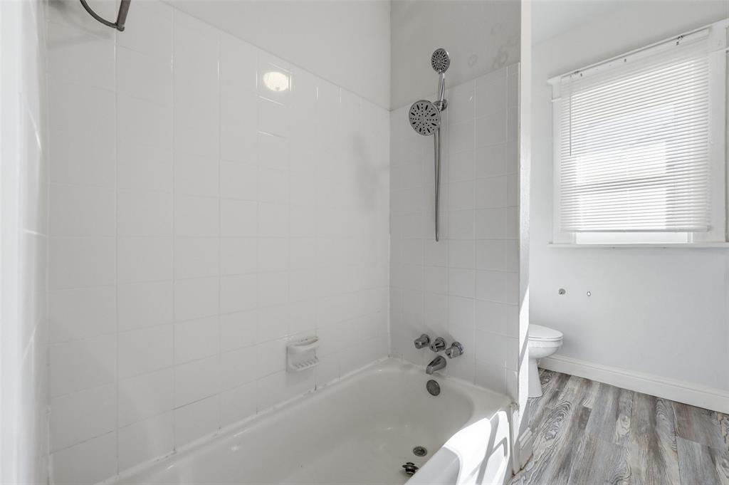 526 South Clinton Avenue Dallas, TX 75208 - Photo 21 of 25 a bathroom with a bathtub and a shower