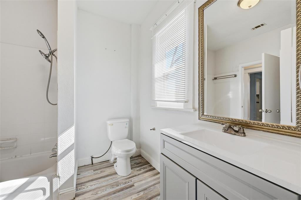 526 South Clinton Avenue Dallas, TX 75208 - Photo 22 of 25 a bathroom with a sink a toilet and a mirror