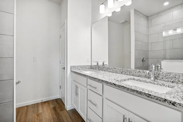 a bathroom with a granite countertop sink and a mirror