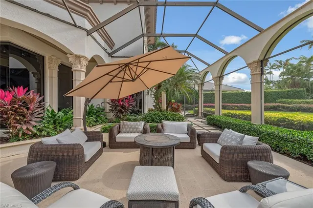 a view of a patio with couches and chairs under an umbrella