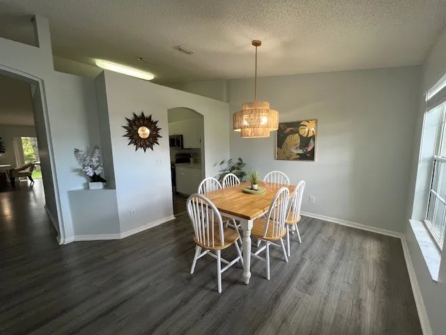 a view of a dining room with furniture a chandelier and wooden floor