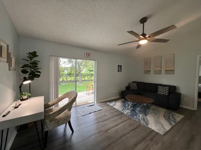 a living room with furniture a potted plant and a large window