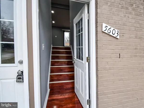 a view of a hallway with wooden floor and entryway