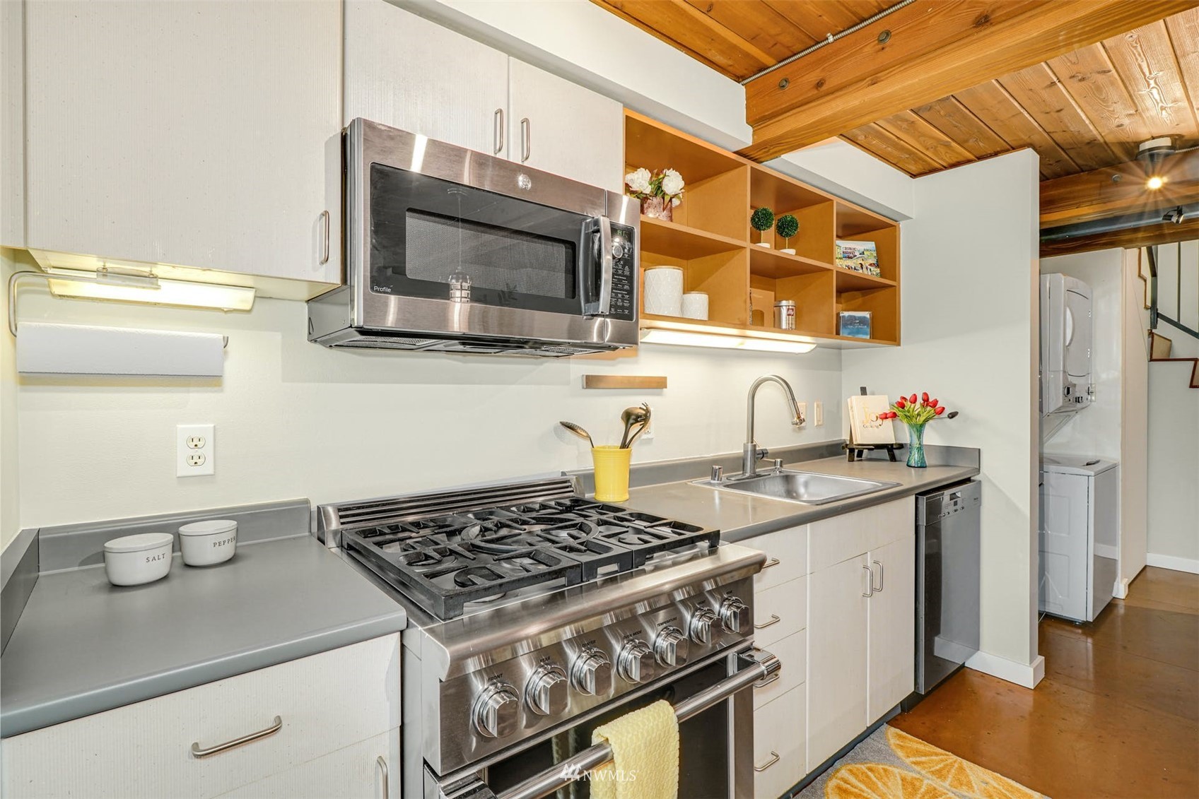 66 Bell Street, Unit 203 Seattle, WA 98121 - Photo 17 of 35 a kitchen with stainless steel appliances granite countertop a stove and a microwave