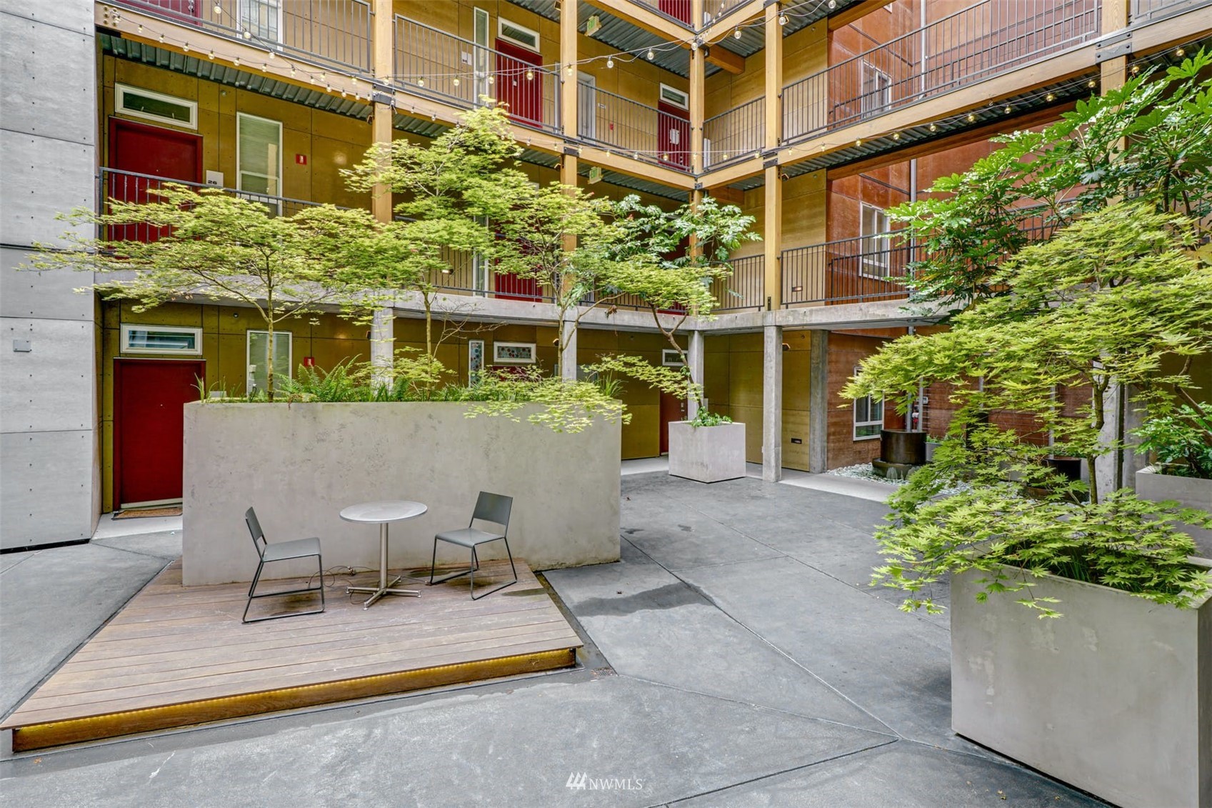 66 Bell Street, Unit 203 Seattle, WA 98121 - Photo 4 of 35 a view of a patio with table and chairs and potted plants