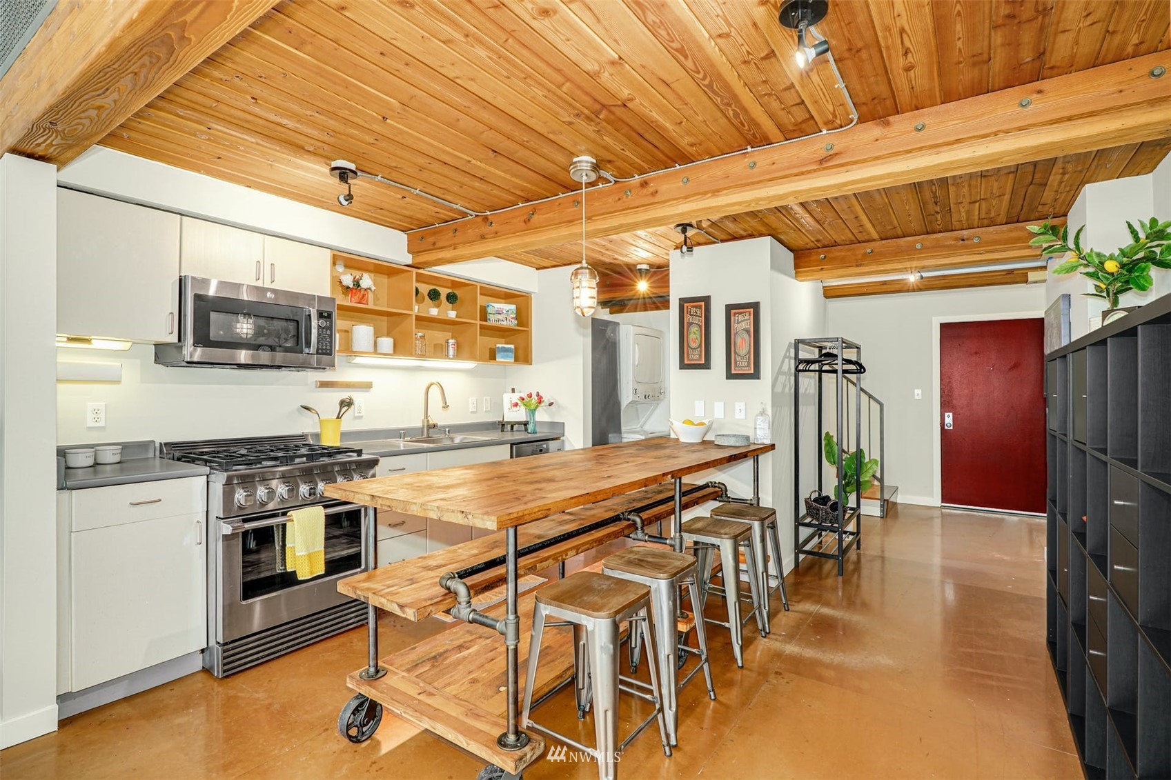 66 Bell Street, Unit 203 Seattle, WA 98121 - Photo 10 of 35 a kitchen with stainless steel appliances granite countertop a stove a refrigerator a sink dishwasher and white cabinets with wooden floor