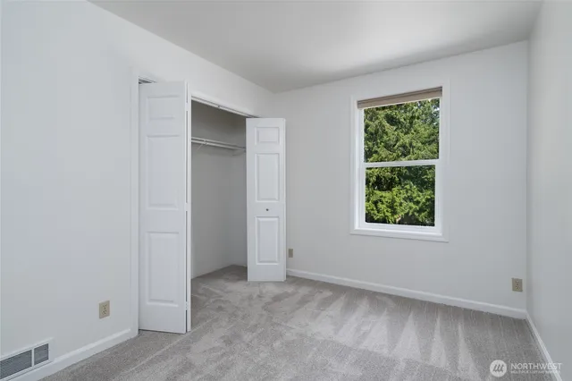 an empty room with windows and closet