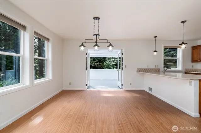 a view of a kitchen with wooden floor and a window