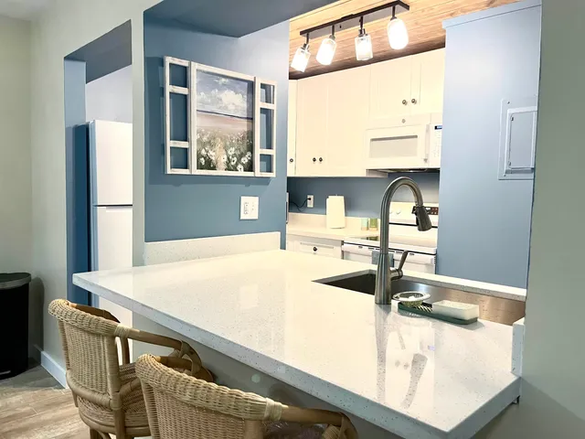 a kitchen with stainless steel appliances granite countertop a sink and a refrigerator