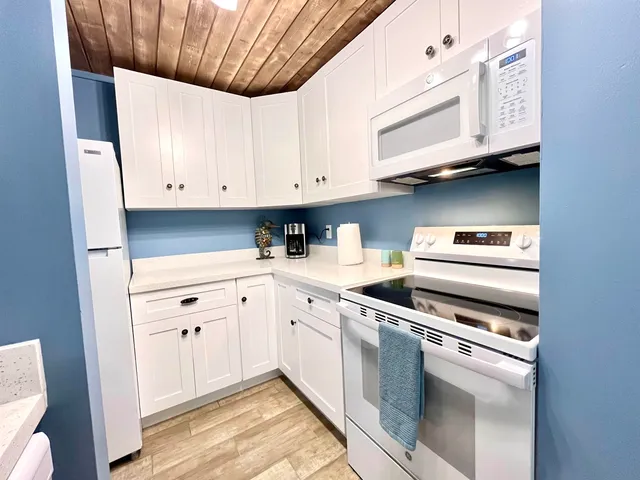 a kitchen with a refrigerator sink and cabinets