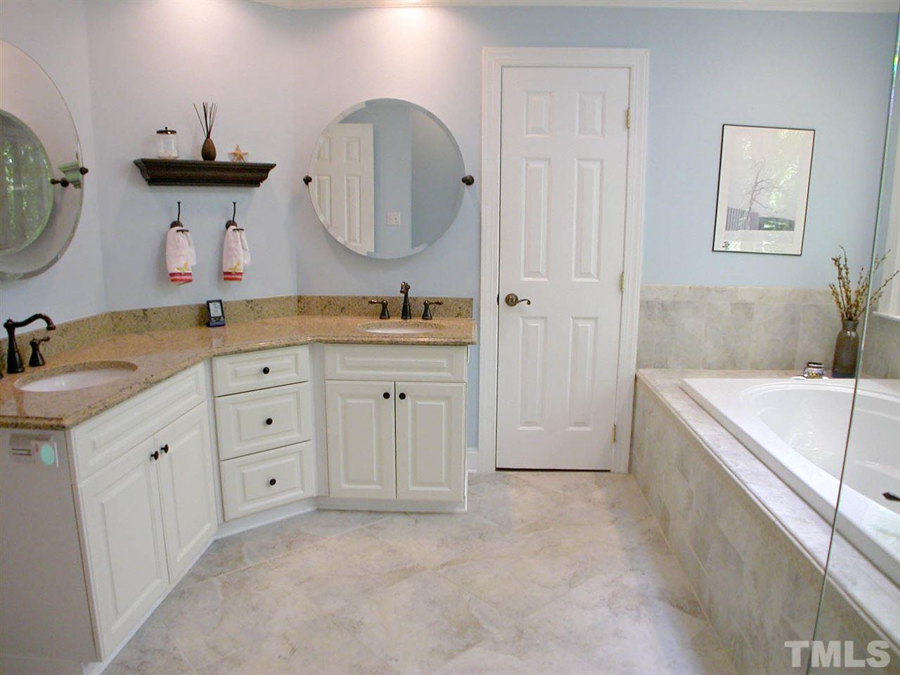 11812 Mountbatten Way Raleigh, NC 27613 - Photo 14 of 25 a spacious bathroom with a granite countertop sink mirror and bathtub