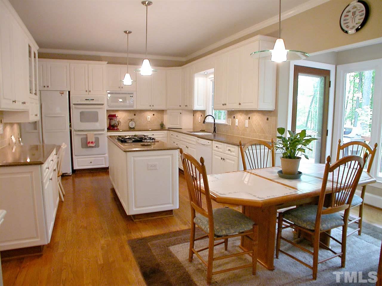 11812 Mountbatten Way Raleigh, NC 27613 - Photo 8 of 25 a kitchen with stainless steel appliances granite countertop a stove a refrigerator a kitchen island a dining table and chairs