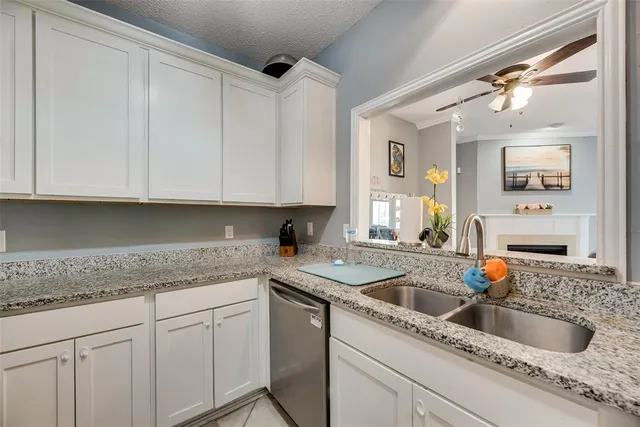 a kitchen with granite countertop a sink dishwasher and cabinets