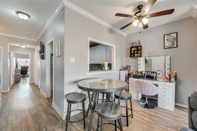 a dining room with wooden floor a chandelier a wooden table and chairs