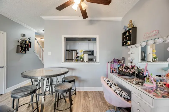 a kitchen with stainless steel appliances kitchen island granite countertop a table chairs and a wooden floor
