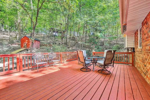 a view of deck with furniture and trees