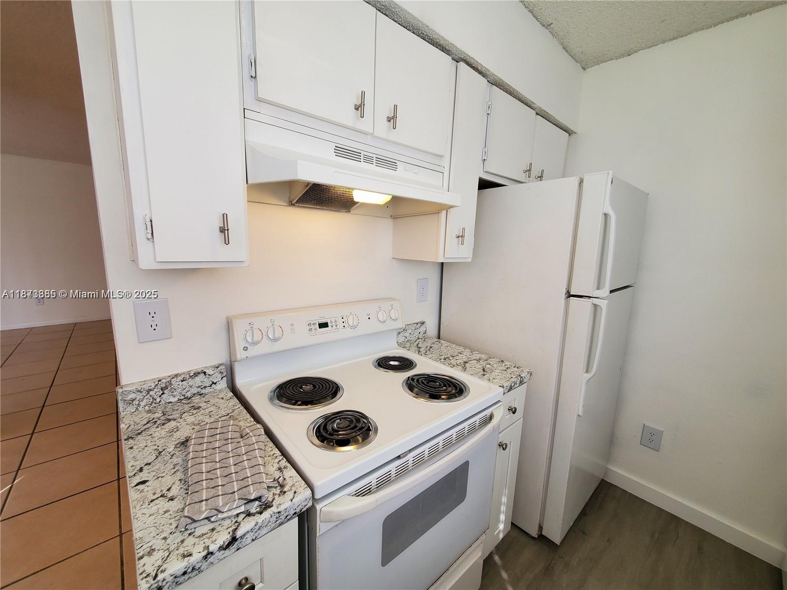 1017 Washington Circle, Unit F Homestead, FL 33034 - Photo 11 of 34 a white stove top oven sitting inside of a kitchen