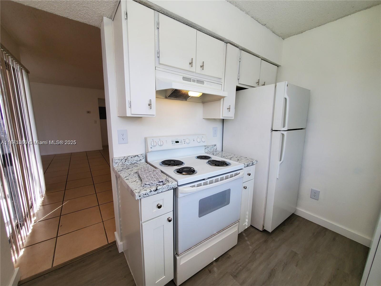 1017 Washington Circle, Unit F Homestead, FL 33034 - Photo 12 of 34 a kitchen with stainless steel appliances white cabinets and a stove