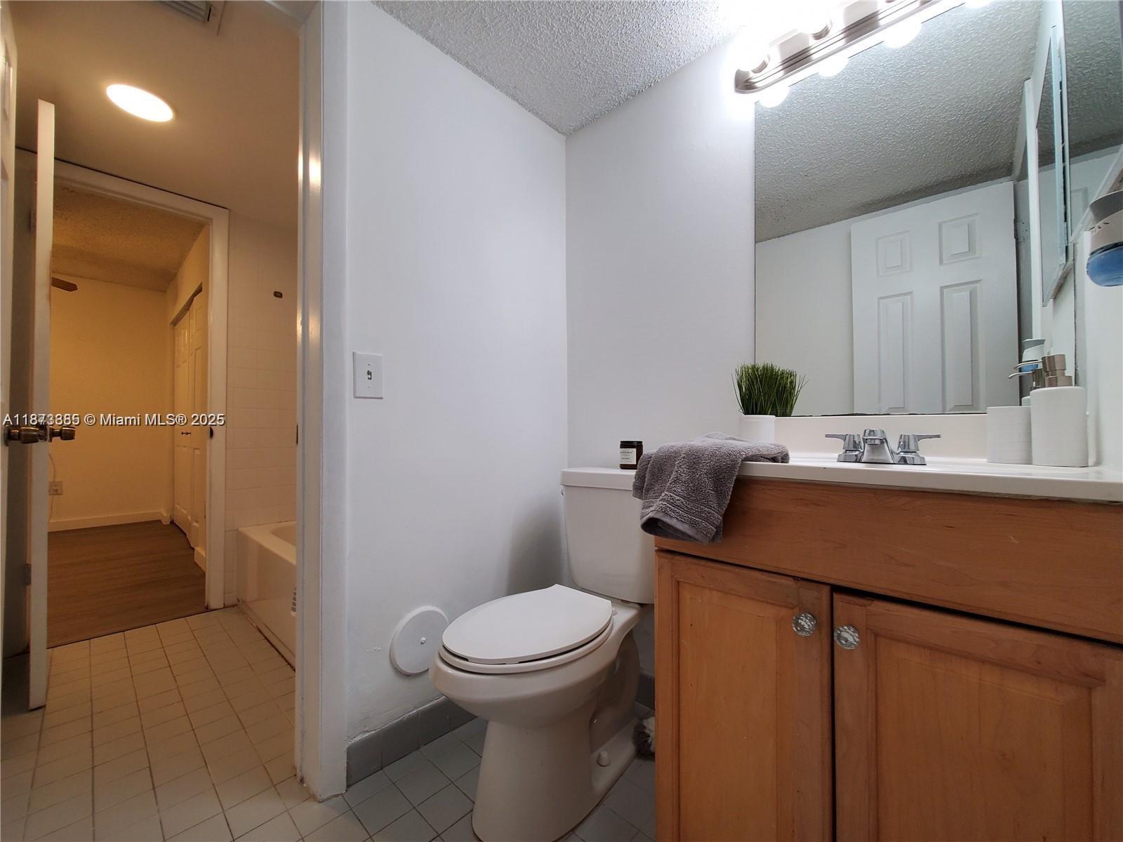 1017 Washington Circle, Unit F Homestead, FL 33034 - Photo 13 of 34 a bathroom with a granite countertop sink toilet and shower