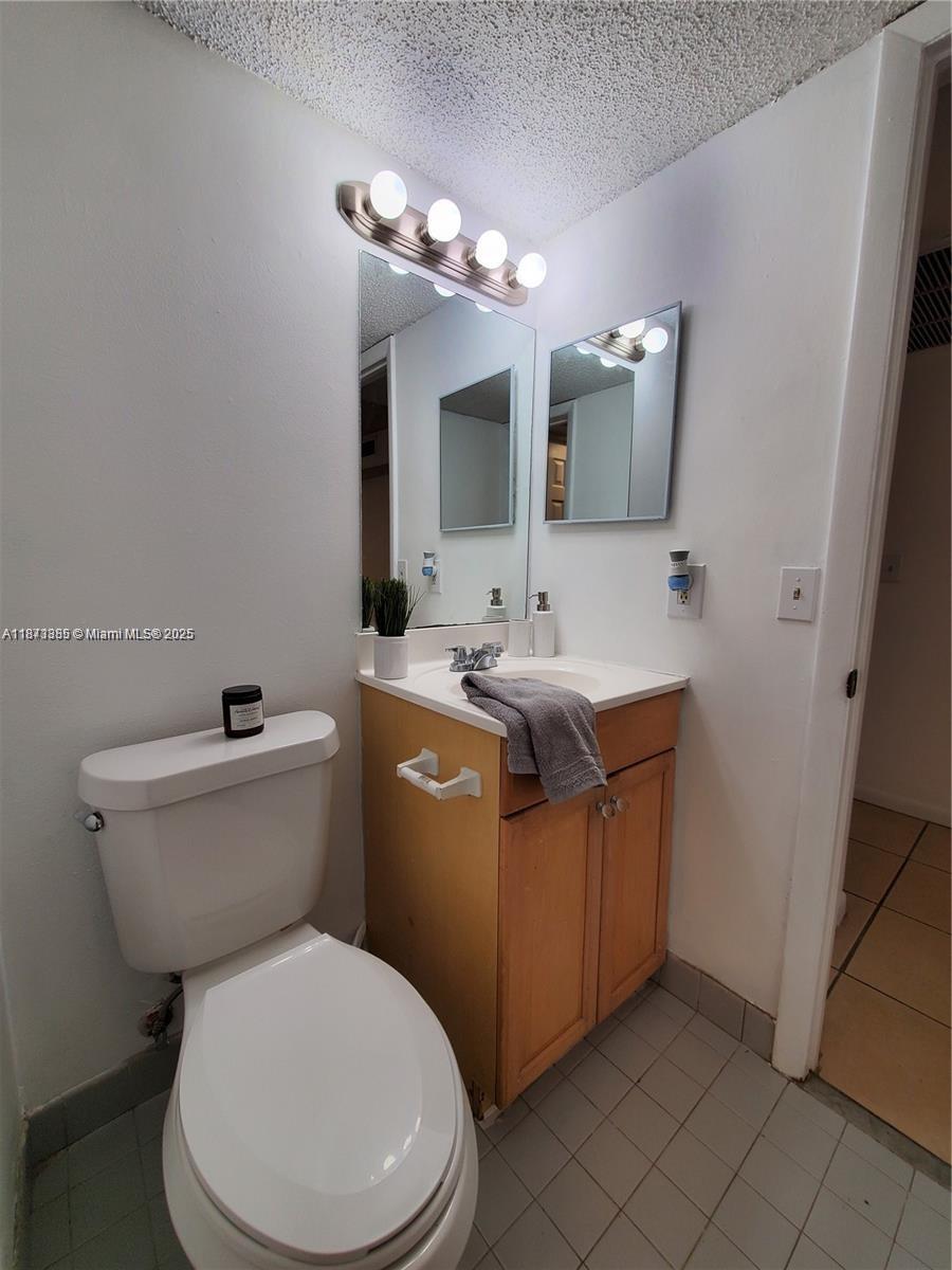 1017 Washington Circle, Unit F Homestead, FL 33034 - Photo 14 of 34 a bathroom with a toilet sink and mirror
