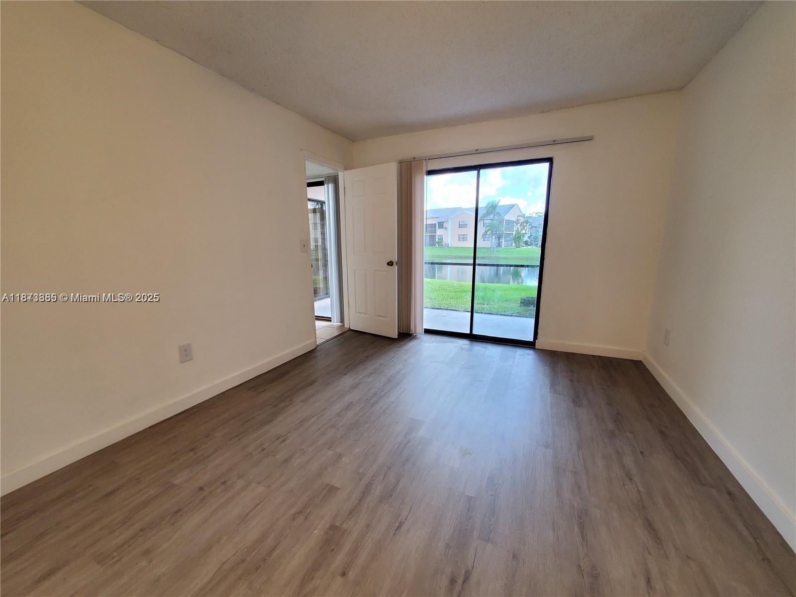 1017 Washington Circle, Unit F Homestead, FL 33034 - Photo 17 of 34 an empty room with wooden floor and windows