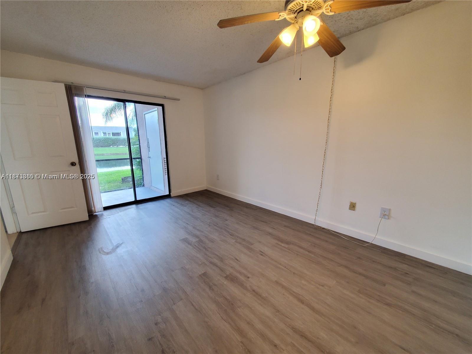 1017 Washington Circle, Unit F Homestead, FL 33034 - Photo 20 of 34 a view of an empty room with wooden floor and a window