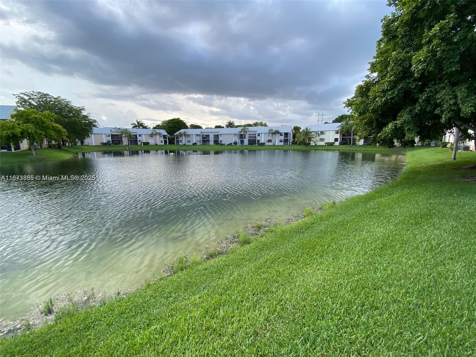1017 Washington Circle, Unit F Homestead, FL 33034 - Photo 33 of 34 a view of a lake in between the city and trees