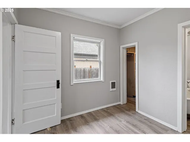 a view of an empty room with closet and a window
