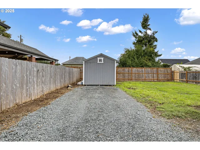 a view of a house with a backyard and a tree