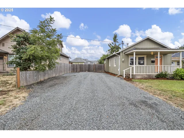 a view of a house with a yard and potted plants