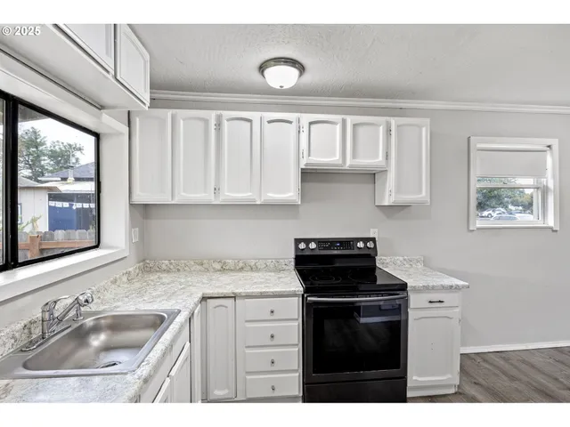 a kitchen with granite countertop a sink cabinets and window