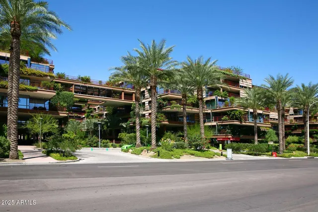 a front view of multi story residential apartment building with yard and sign board