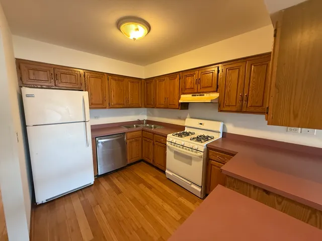 a kitchen with a refrigerator sink and cabinets