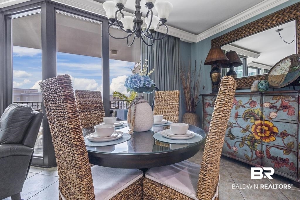 27582 Canal Road, Unit 2408 Orange Beach, AL 36561 - Photo 10 of 47 Tiled dining area with ornamental molding and a chandelier