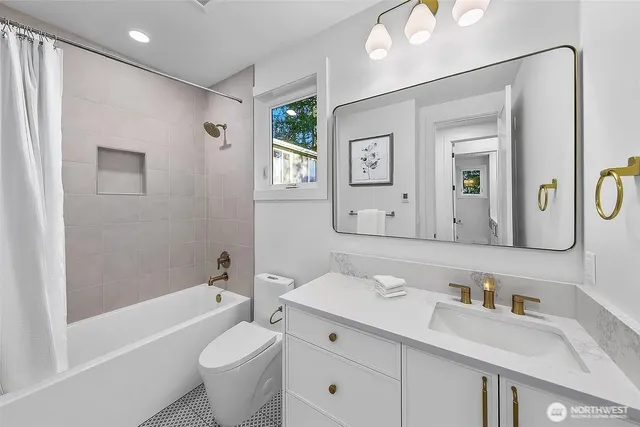 a bathroom with a toilet a sink a tub and a mirror