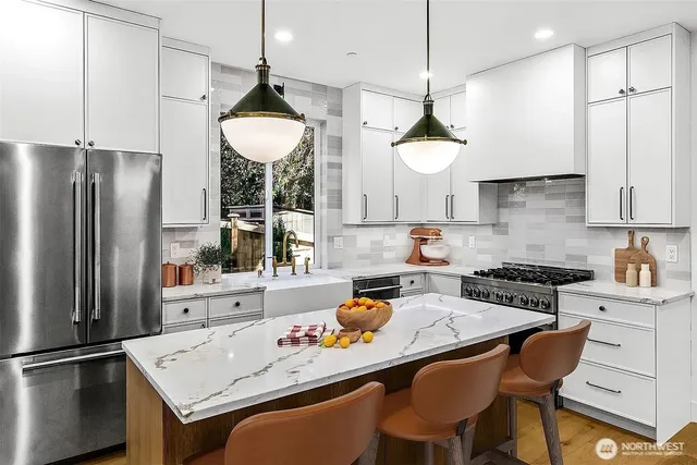 a kitchen with stainless steel appliances granite countertop a sink stove and refrigerator