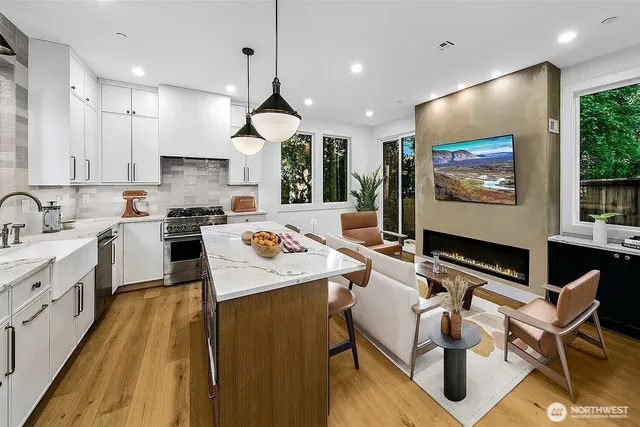 a large kitchen with kitchen island a stove a sink a dining table and chairs