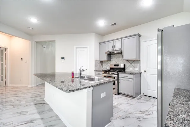 a kitchen with stainless steel appliances granite countertop a sink stove and refrigerator