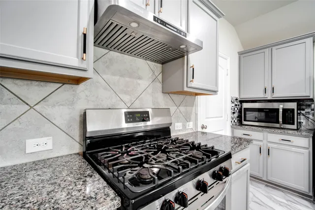 a kitchen with stove top oven and cabinets