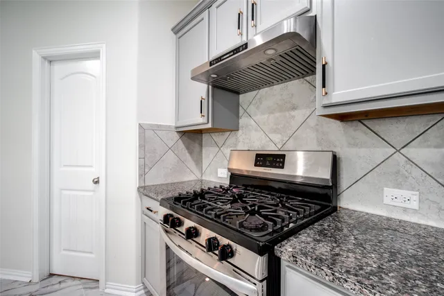 a stove top oven sitting inside of a kitchen